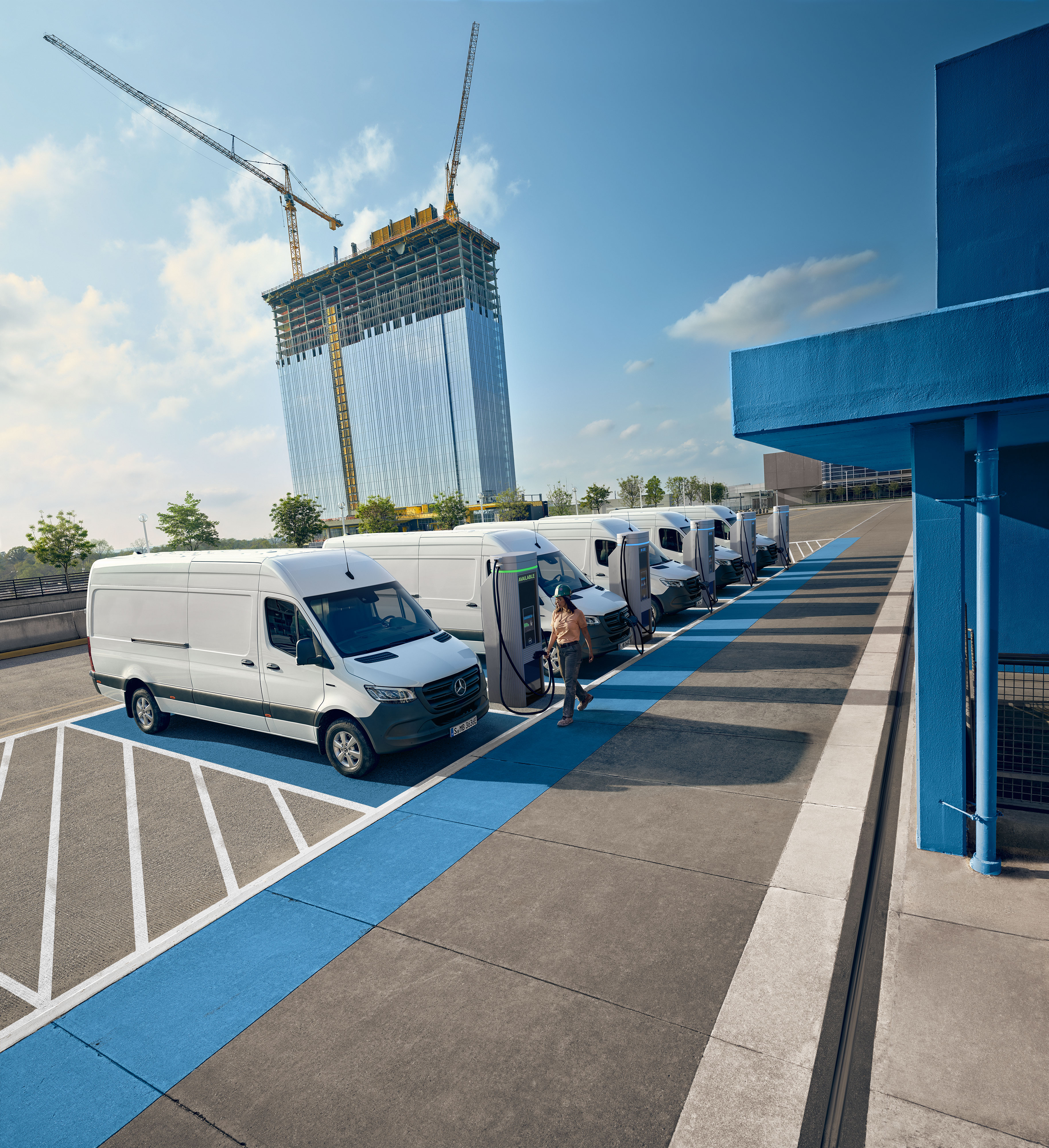 Mercedes-Benz | Convenience A fleet of white electric Mercedes-Benz vans parked at a charging hub station.