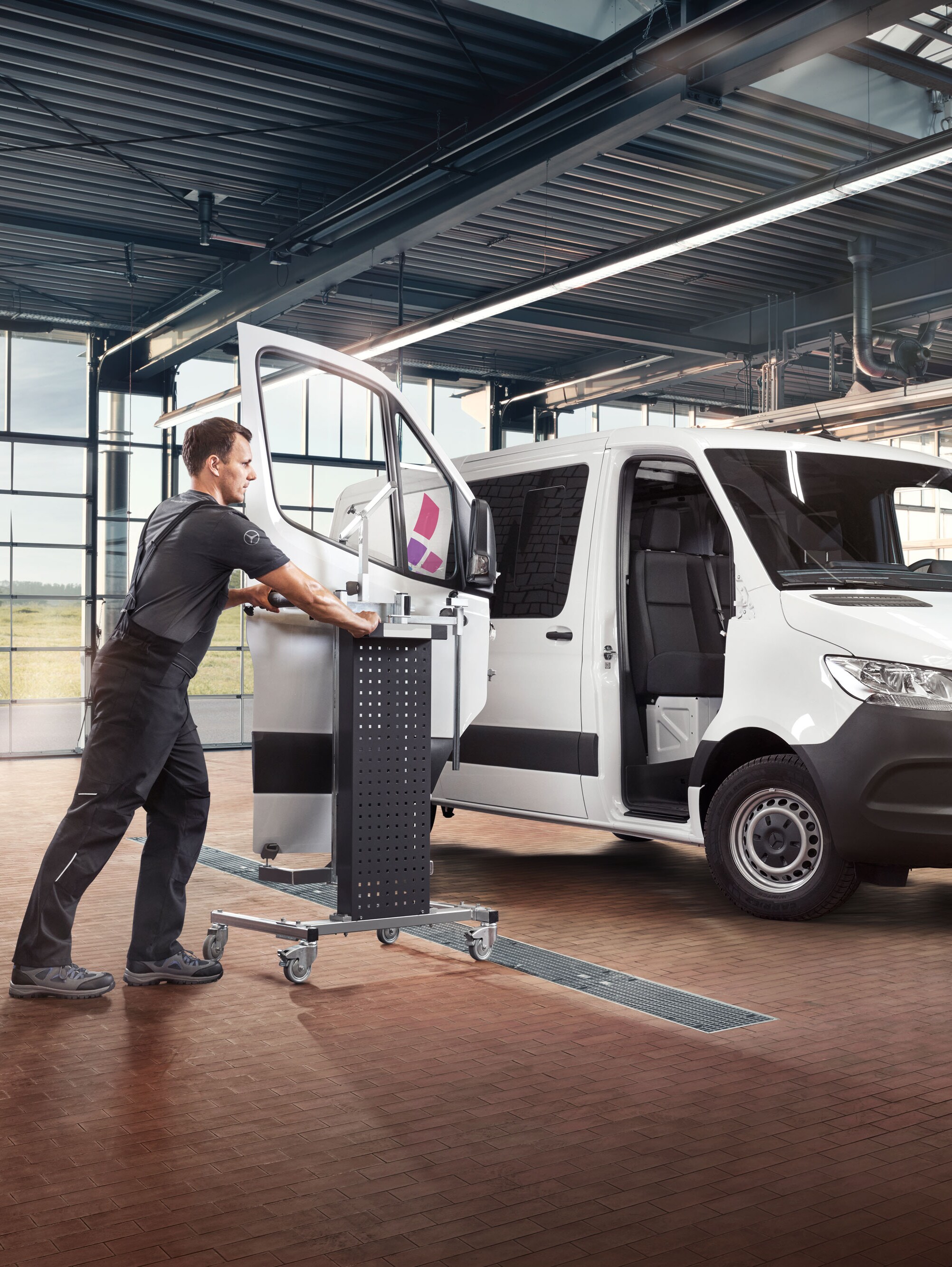 Mercedes specialist using Mercedes-Benz Xentry and special tools on a van in a modern workshop.