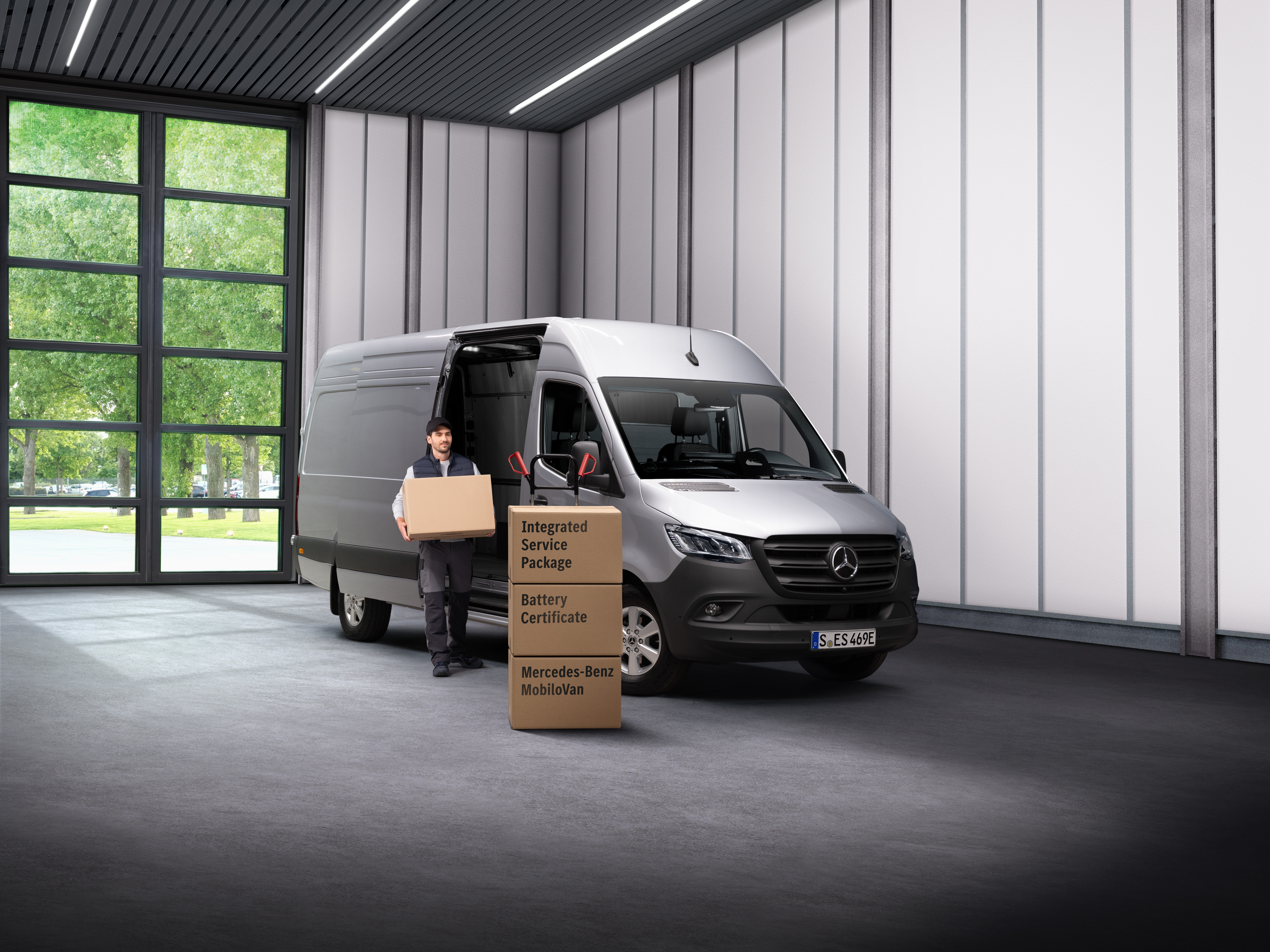 Mercedes-Benz | Electric Vehicle Service A Mercedes-Benz electrical service employee carrying boxes out of a transport