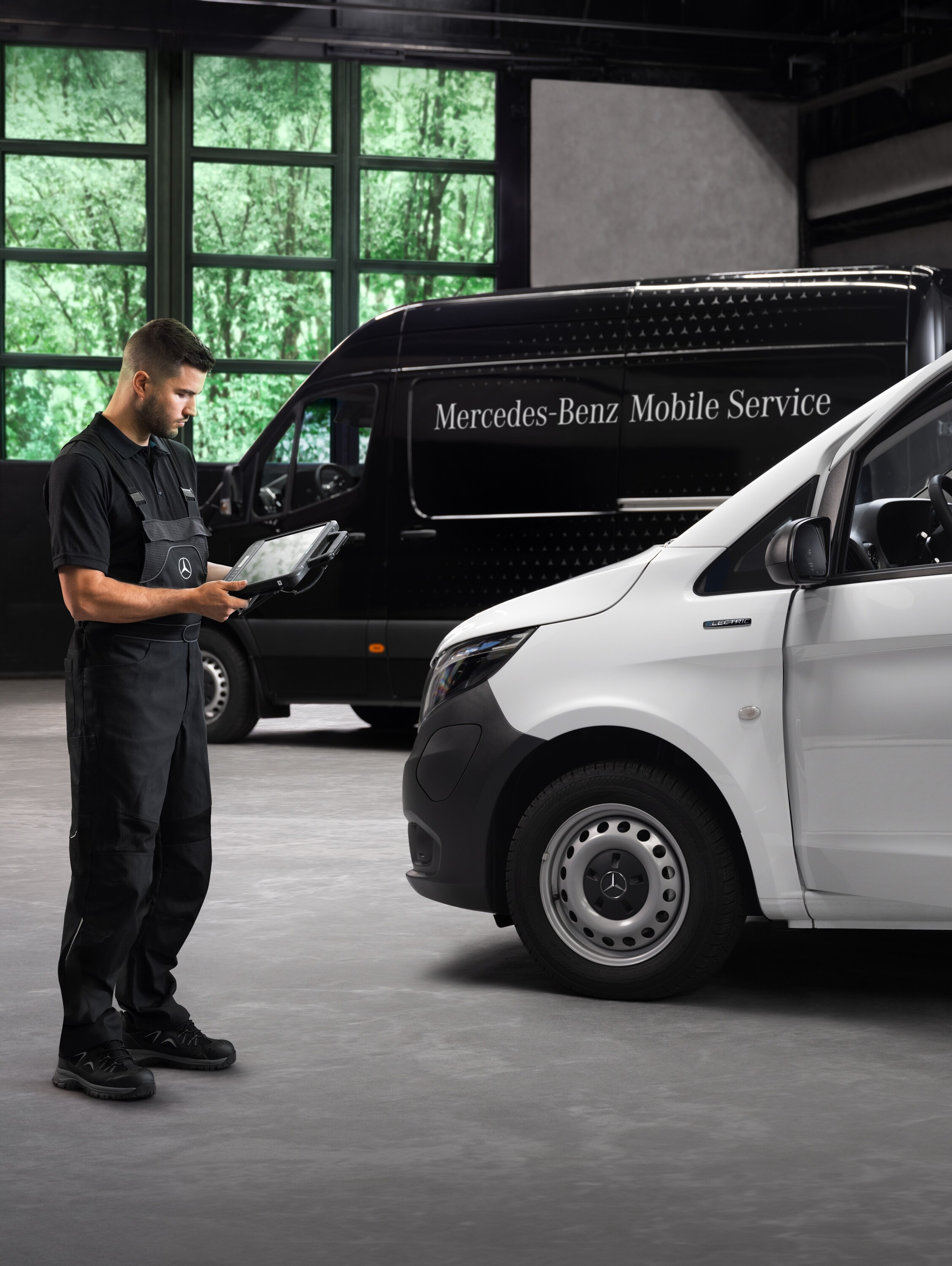 A technician checks a white Mercedes-Benz Vito van in the workshop.