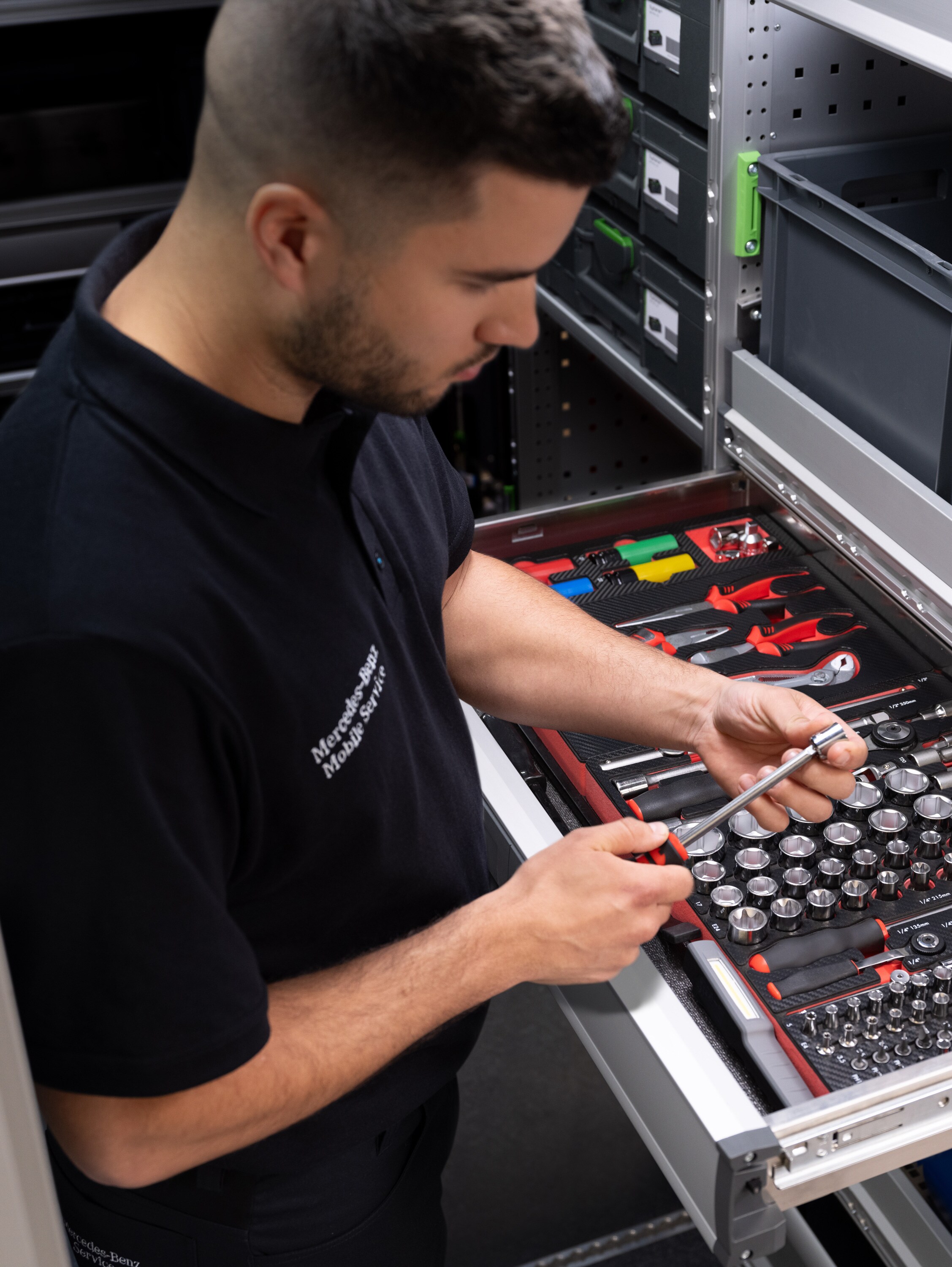 A technician selects an item from a draw full of tools.