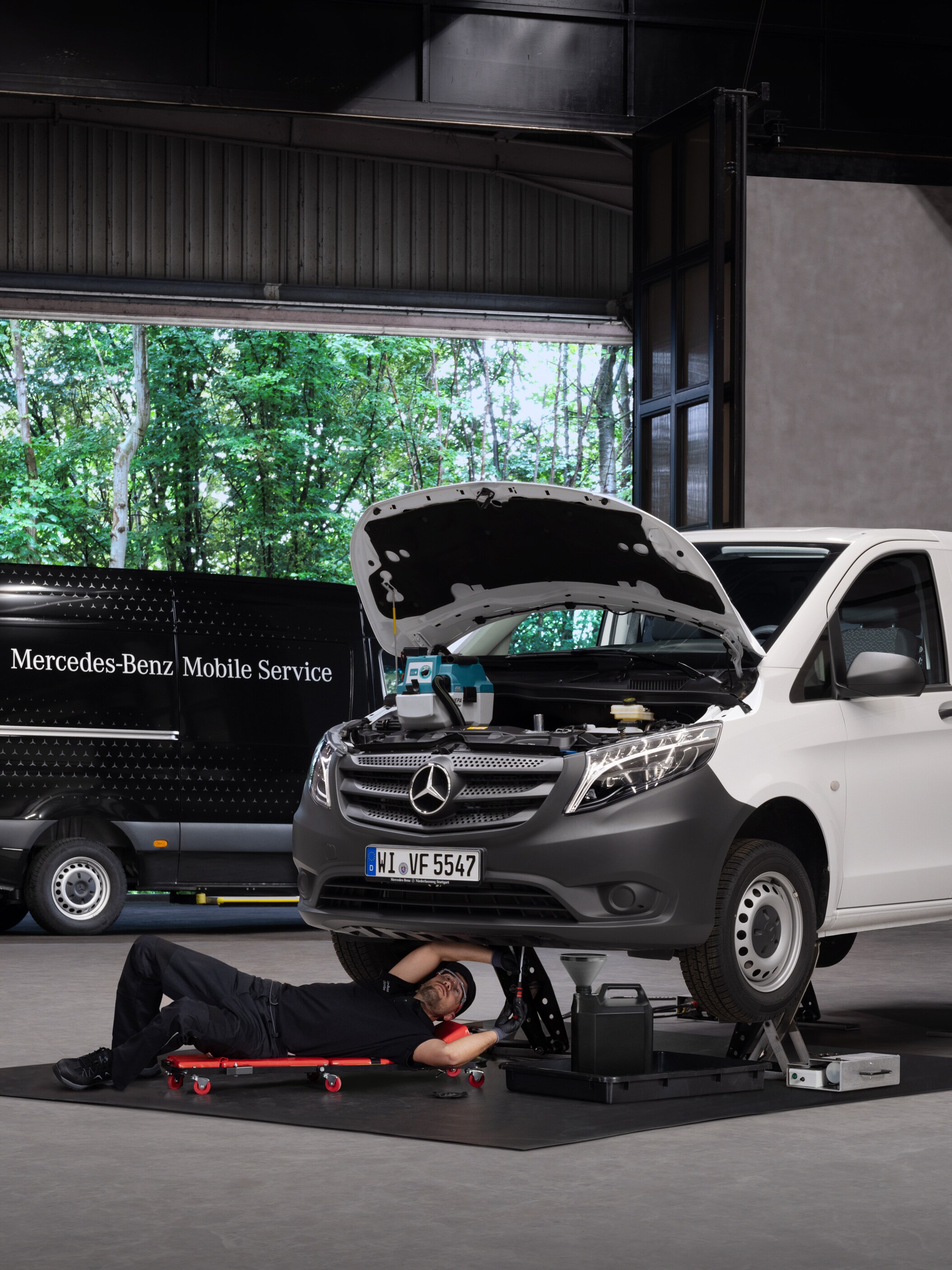 A technician repairs a white Mercedes-Benz Vito van.