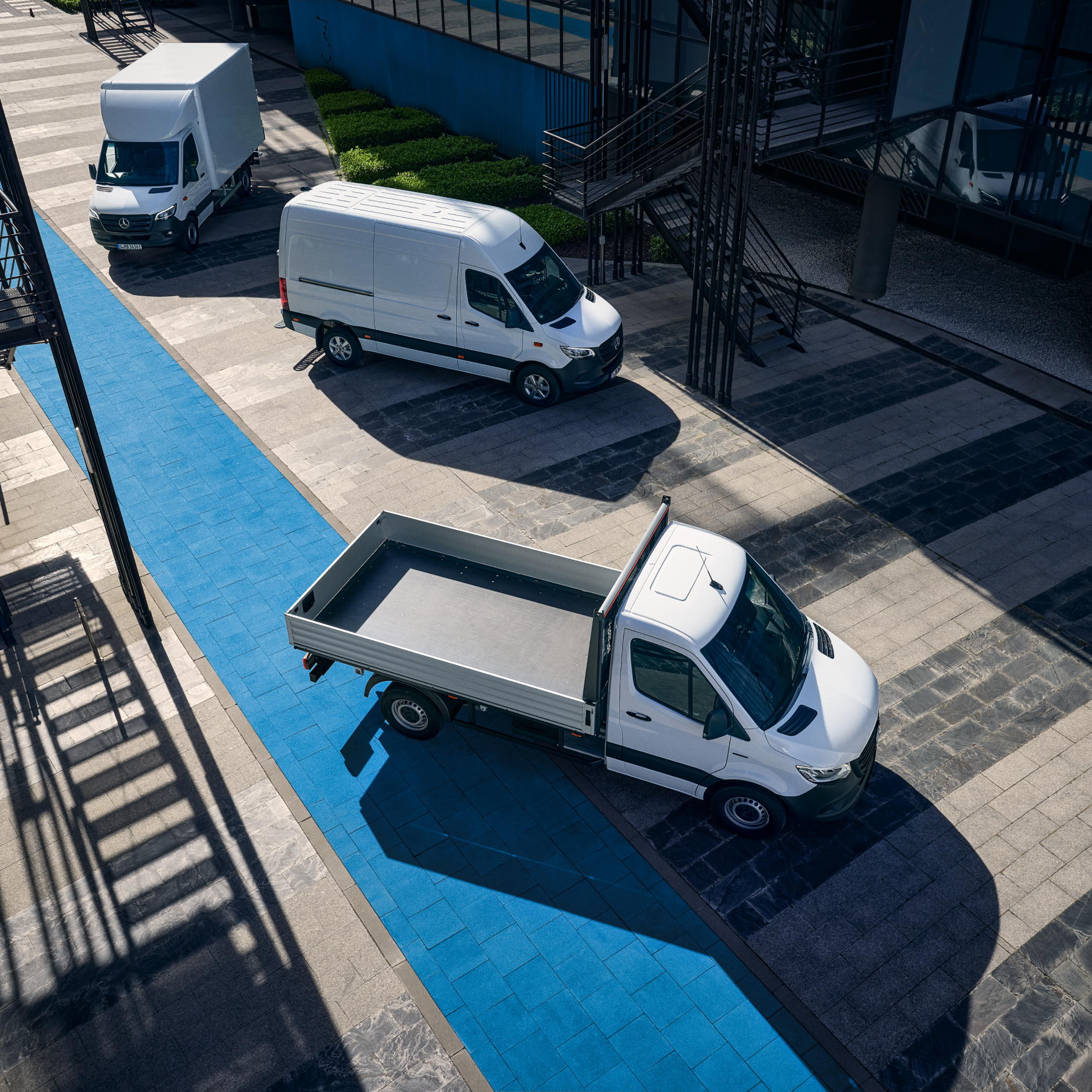 eSprinter Vans | Mercedes-Benz Vans White Mercedes-Benz eSprinter Panel, Chassis Platform and Luton Box Vans all parked outside an office building.