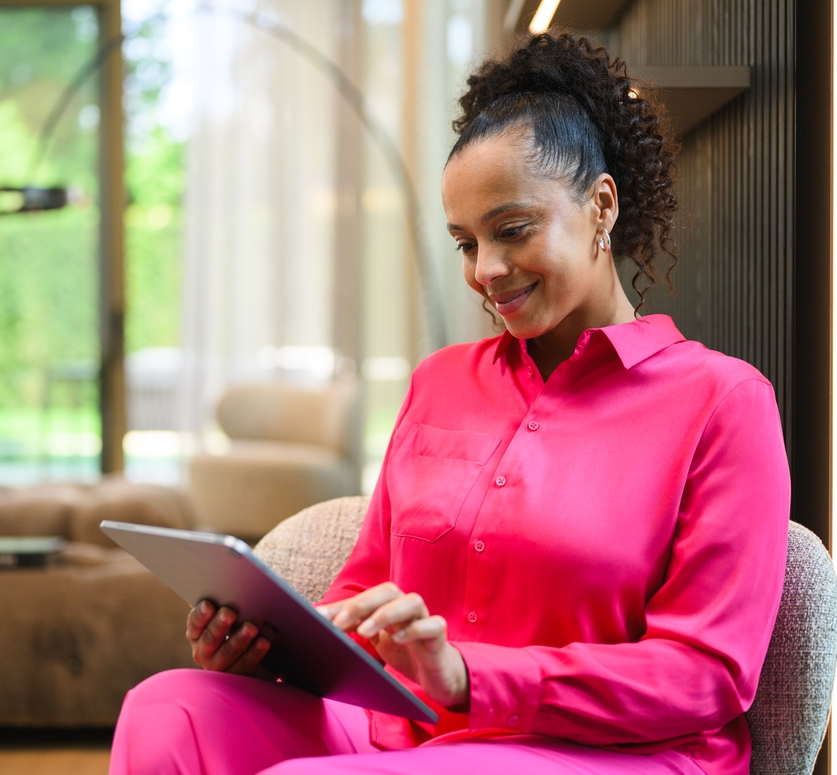 Mercedes-Benz Finance Portal A person at home looking at a tablet device and smiling