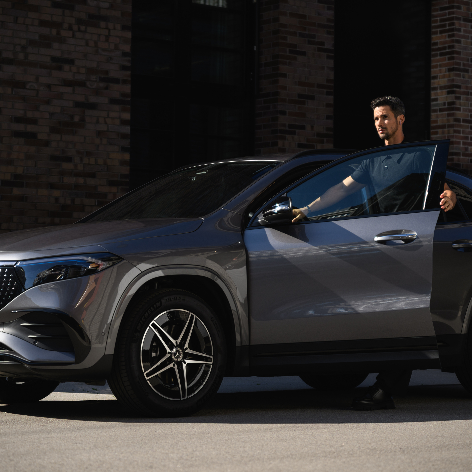 Insurance A person opening a car door and standing next to a Mercedes-Benz vehicle.