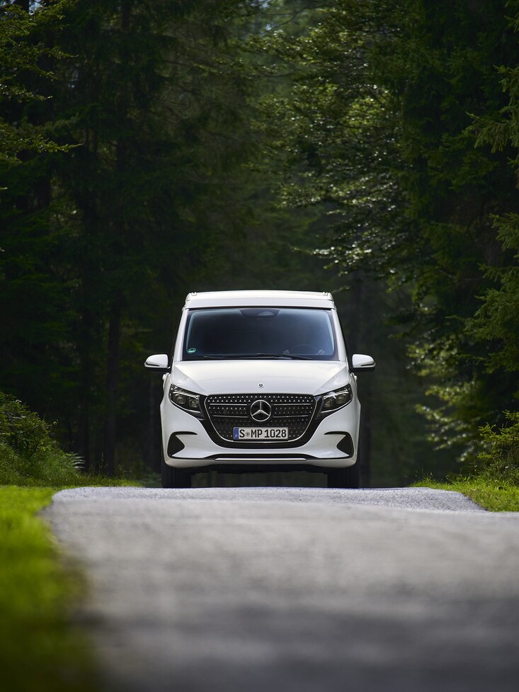 A white Mercedes-Benz MPV on the road.